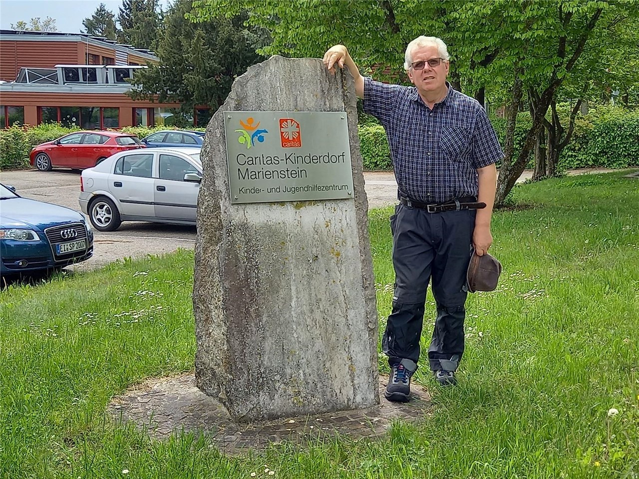 Maximilian Nieberle neben Eingangsschild im Kinderdorf